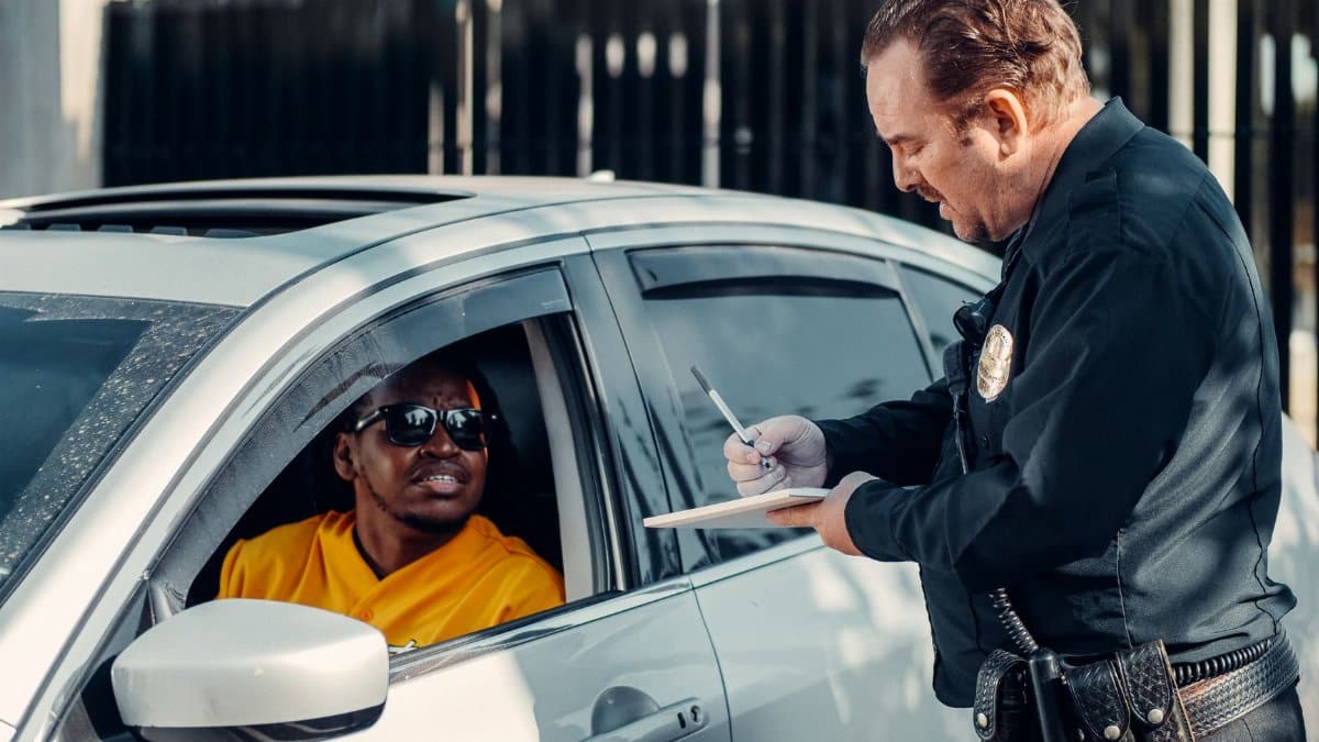 Police officer writes a traffic ticket for a driver during a routine stop.