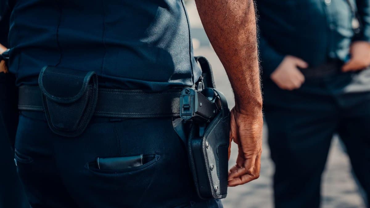 Close-up of a police officer's firearm securely holstered at the waist, conveying professionalism and readiness.