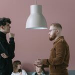 A group of young professionals engaging in a casual office meeting with a modern and stylish backdrop.