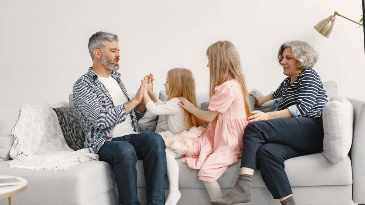 A joyful family spends quality time together, playing and bonding on a cozy sofa.