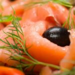 Delicious smoked salmon salad with olives, capers, and fresh dill leaves, perfect for a gourmet dish.