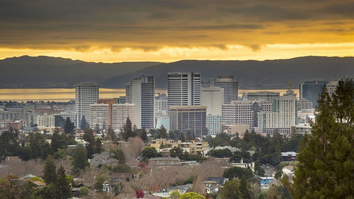 Skyline of Oakland, California at sunset with dramatic skies.