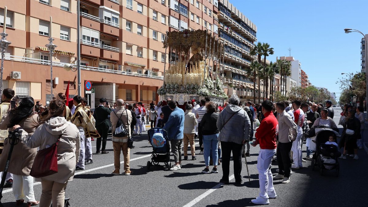 A vibrant Semana Santa procession with people gathered in Cádiz, Spain.
