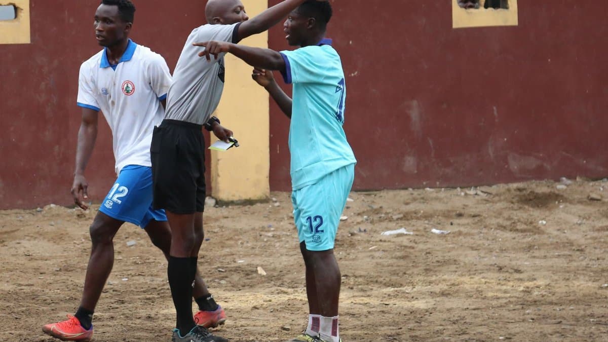Soccer players and referee in heated discussion during a local match, highlighting sportsmanship.