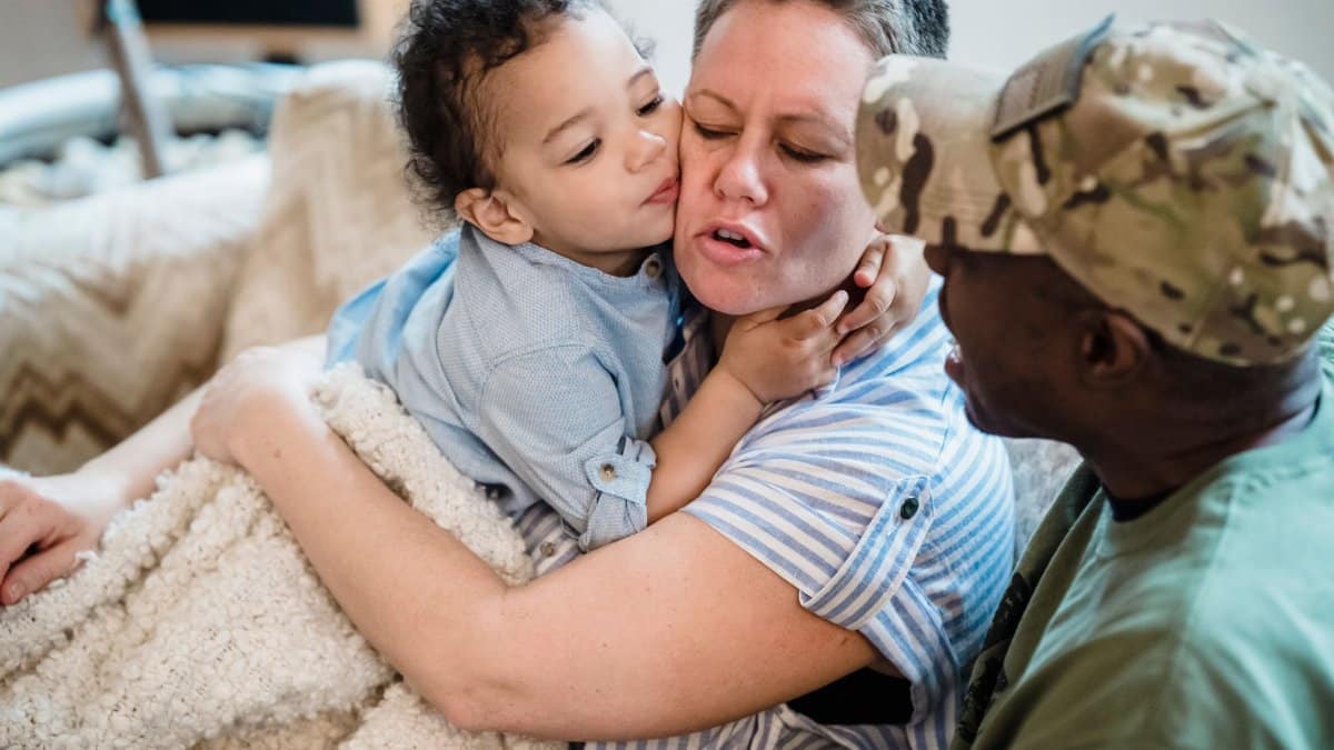 Child hugging parent while sitting together, capturing a warm family moment indoors.