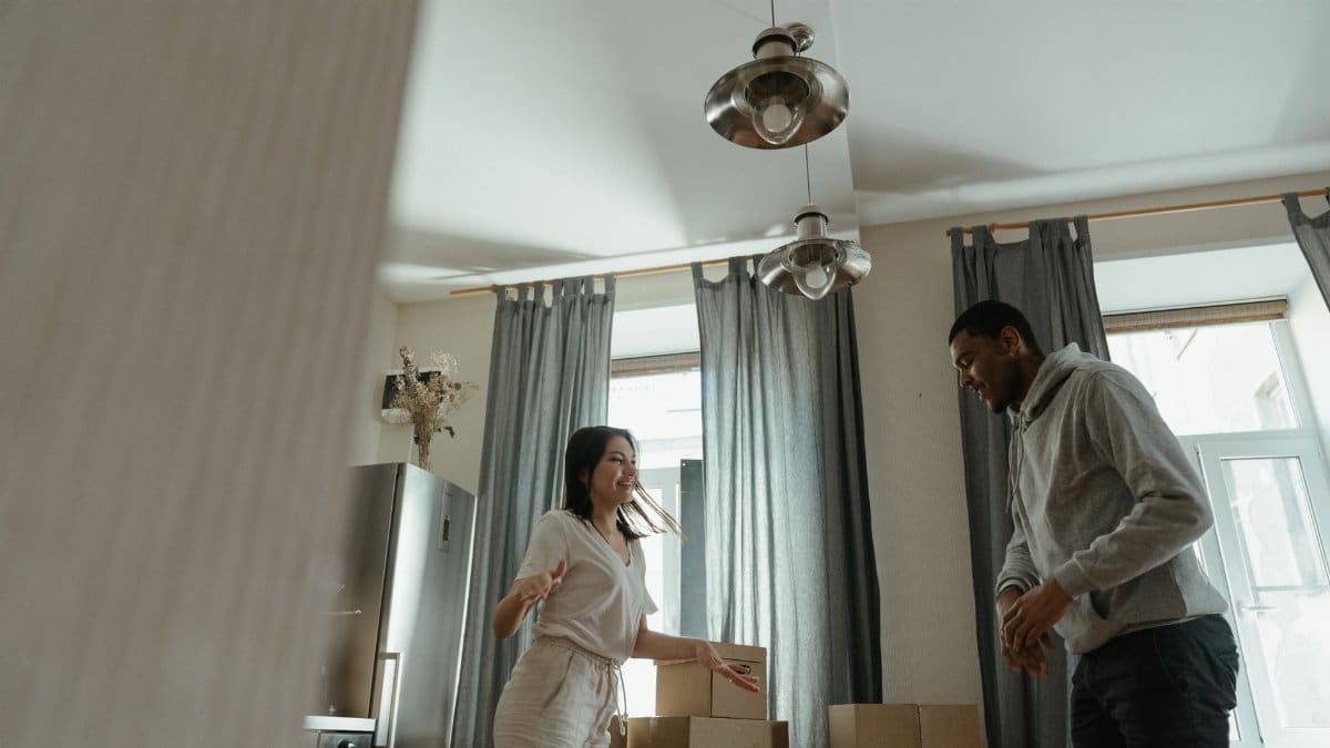 A joyful couple unpacks boxes in their new home, celebrating a fresh start.