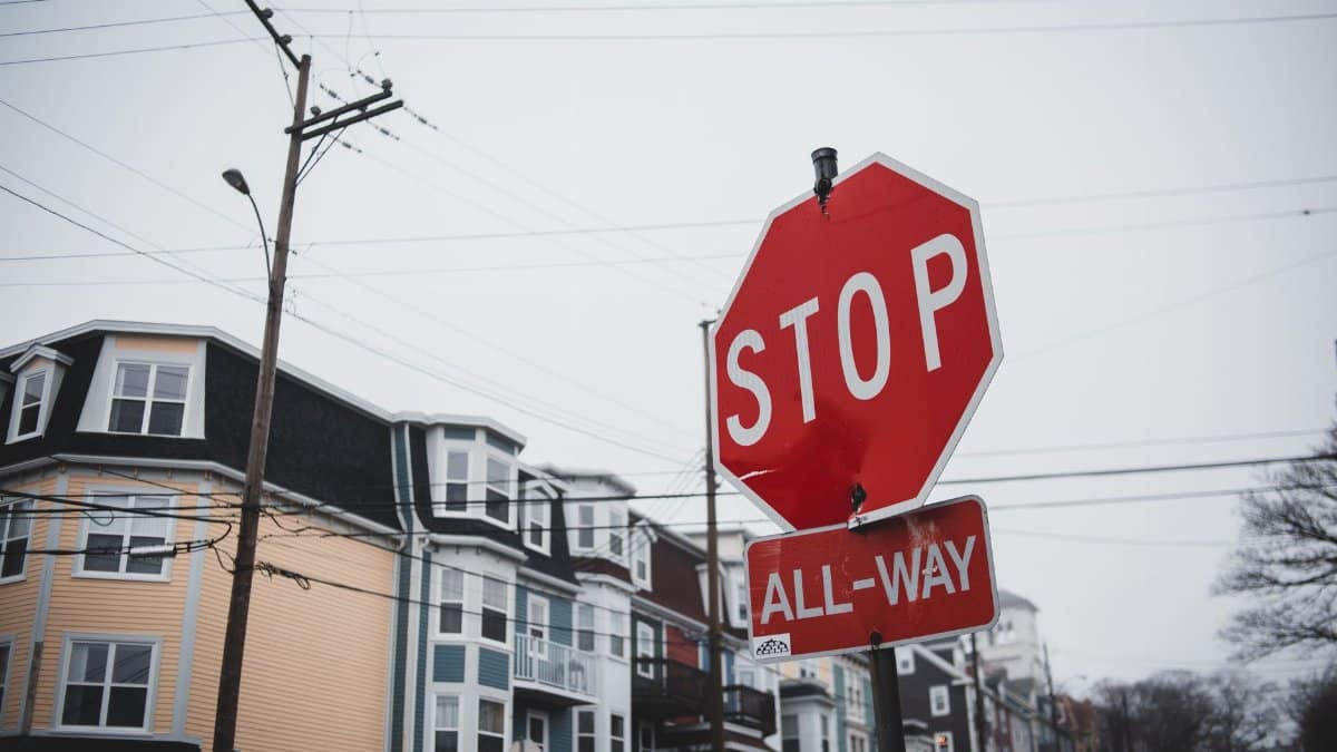 Warning signs with inscriptions on city street with residential buildings in gloomy day