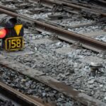 Detailed view of train tracks featuring a red signal light and numbered marker 158.