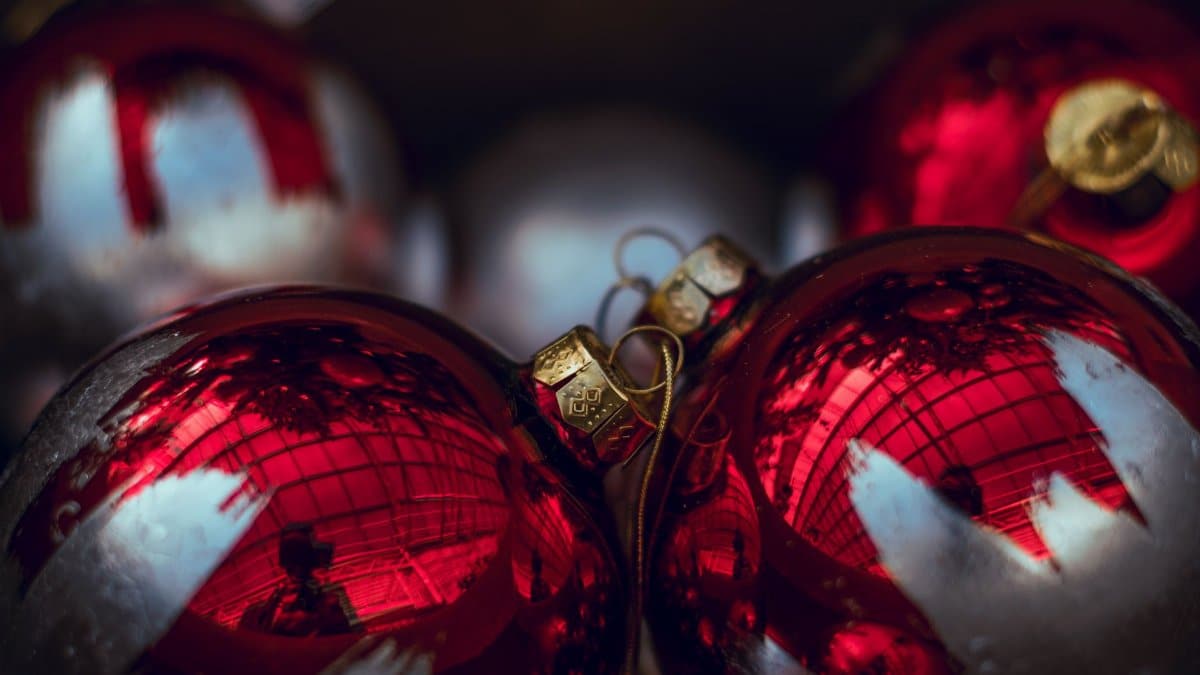 Shiny red Christmas ornaments reflecting light, perfect for holiday decor themes.