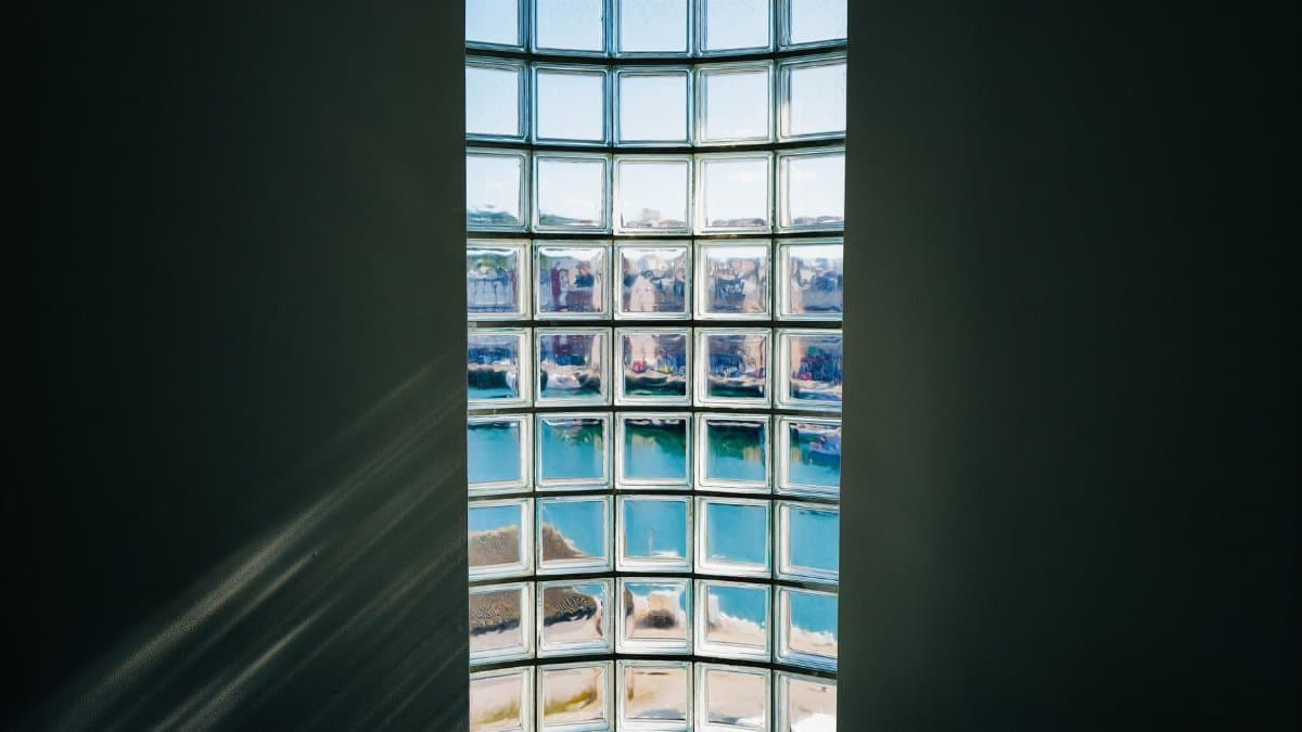 A beautiful view of the cityscape through a glass block window, capturing bright reflections.