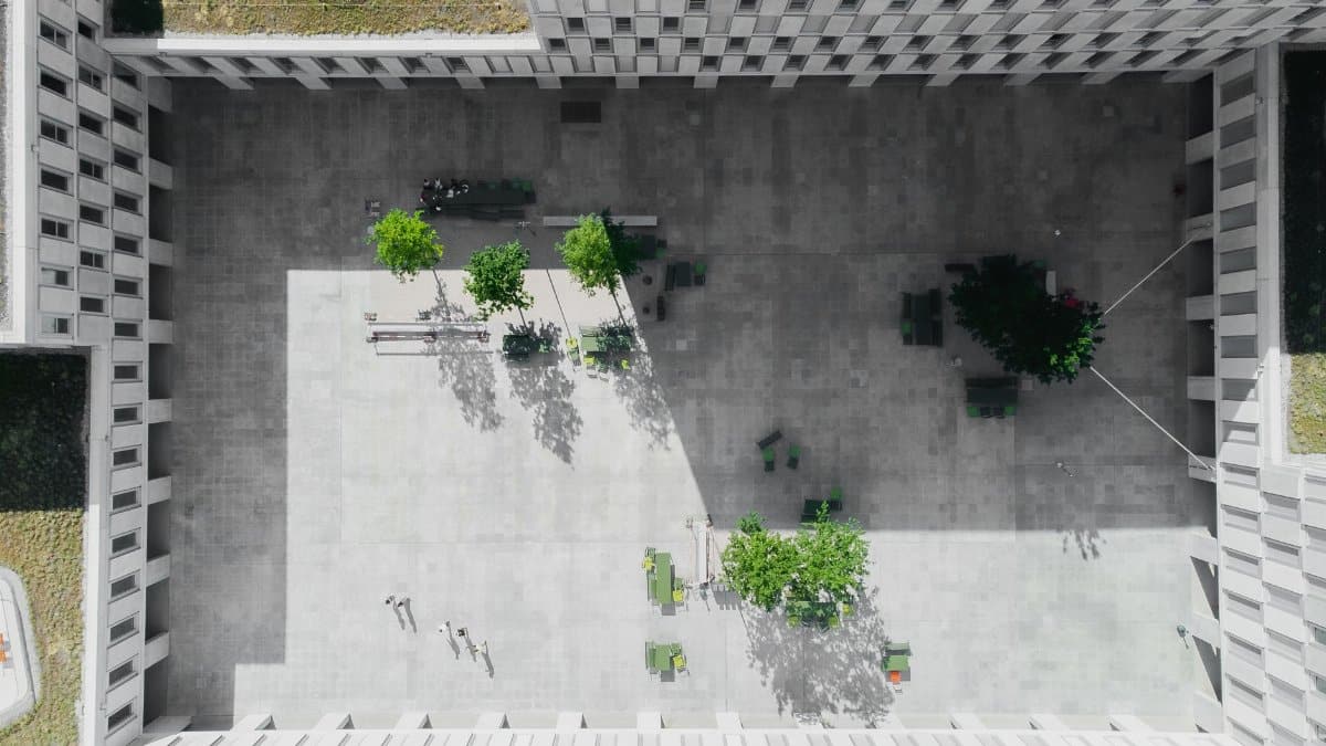An aerial view showcasing the modern architecture of a courtyard with green spaces in Viganello, Switzerland.