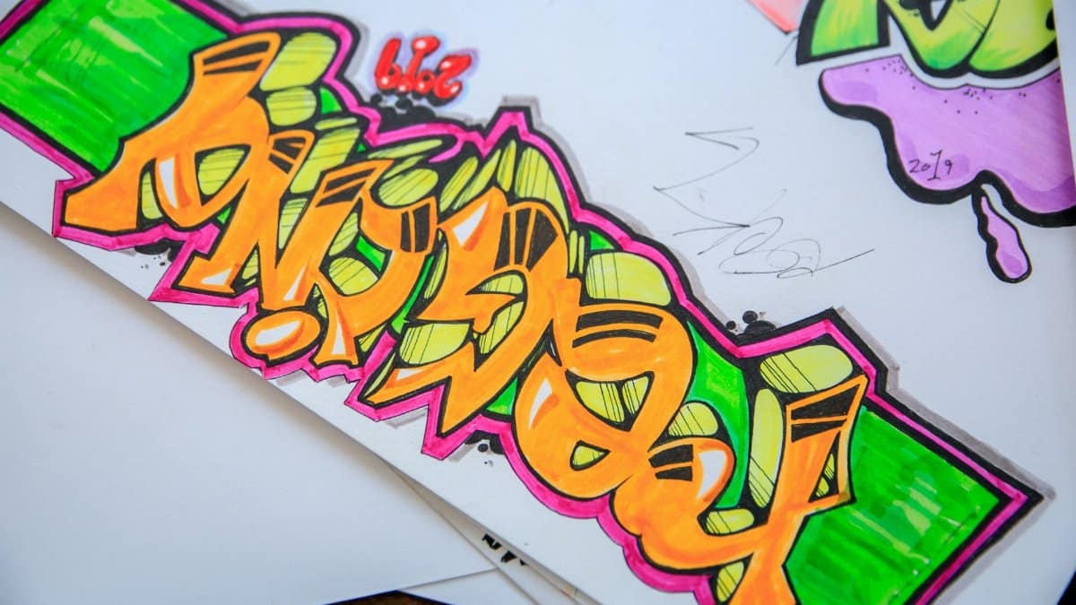 Colorful street art graffiti drawn on paper with vibrant colors and bold designs.