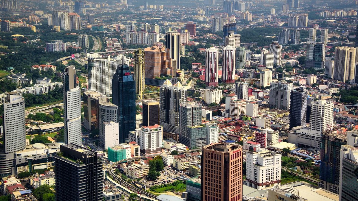 Vibrant aerial view of Kuala Lumpur's modern skyline with towering skyscrapers.