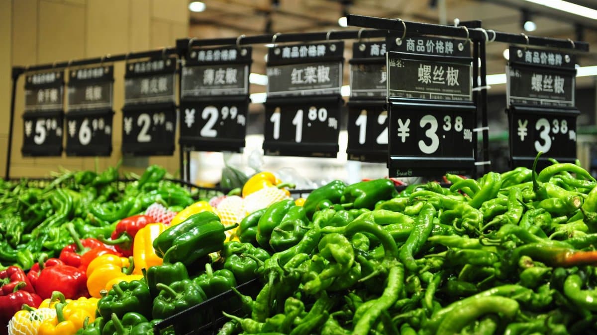 Vibrant bell peppers on display in a Chinese market with price tags.