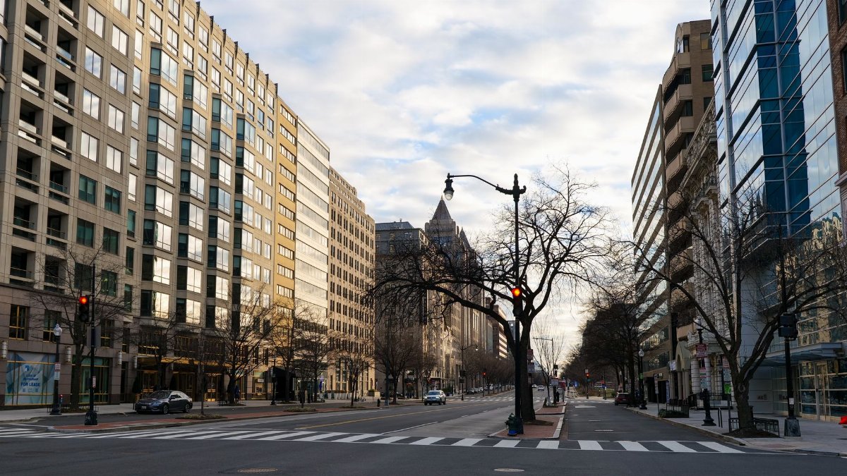 A deserted street in Washington DC showcasing modern urban architecture under a cloudy sky.