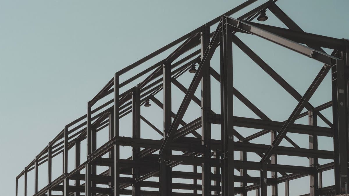 Modern steel framework structure under clear sky, showcasing architectural design.