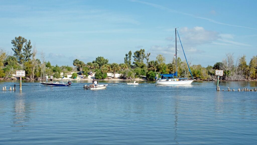 Boats sail on Haulover Canal under a clear blue sky in Mims, Florida.