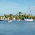 Boats sail on Haulover Canal under a clear blue sky in Mims, Florida.