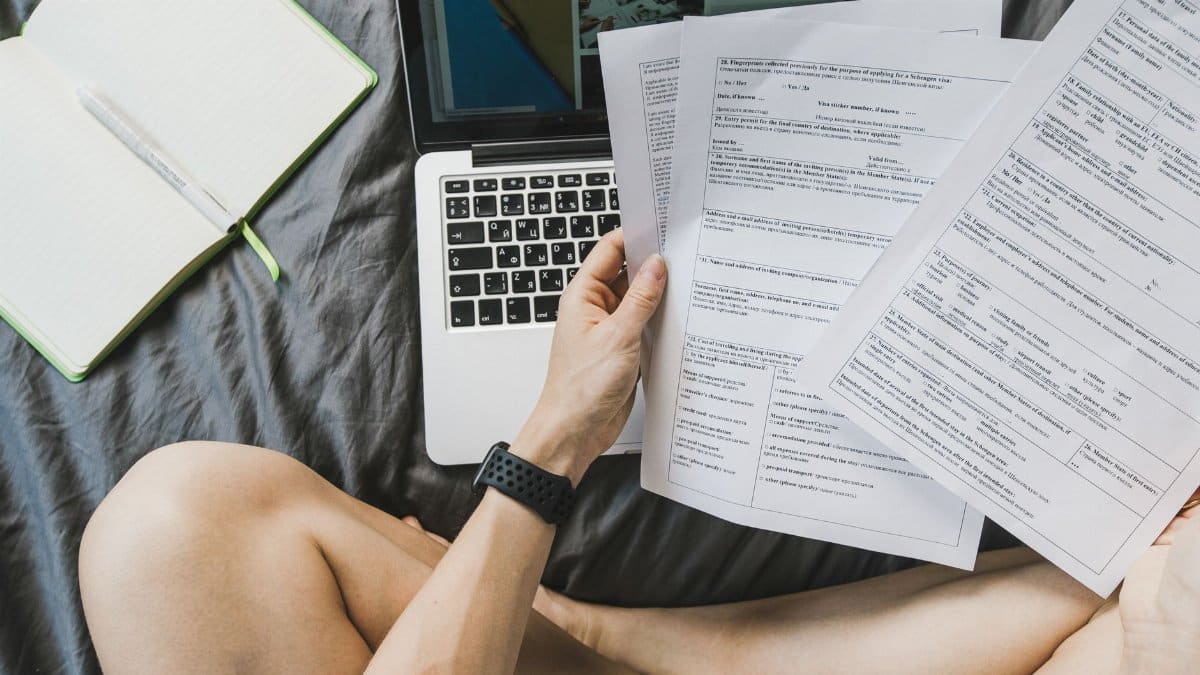 Freelancer managing documents on a laptop from home for productivity.
