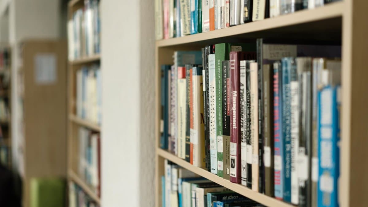 Close-up of bookshelves filled with diverse literature in a quiet library setting.