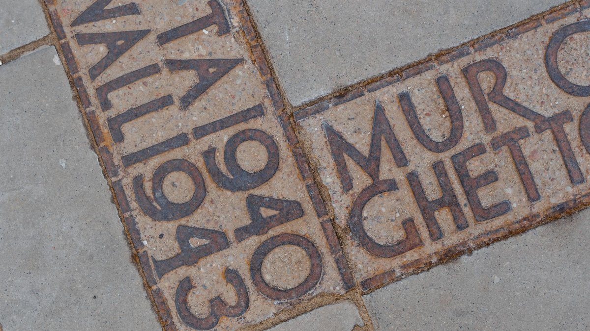 Close-up of historic engravings on stone pavement with significant cultural dates.