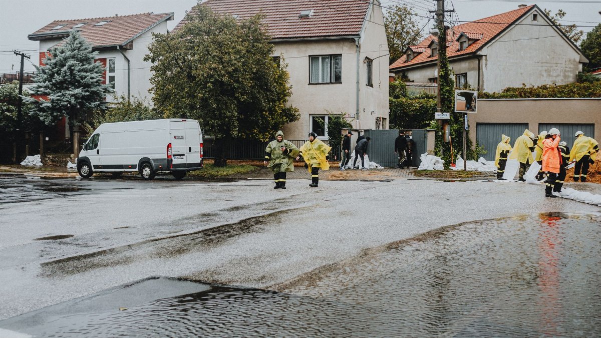 Emergency response team members handle city flooding, deploying sandbags and wearing gear.
