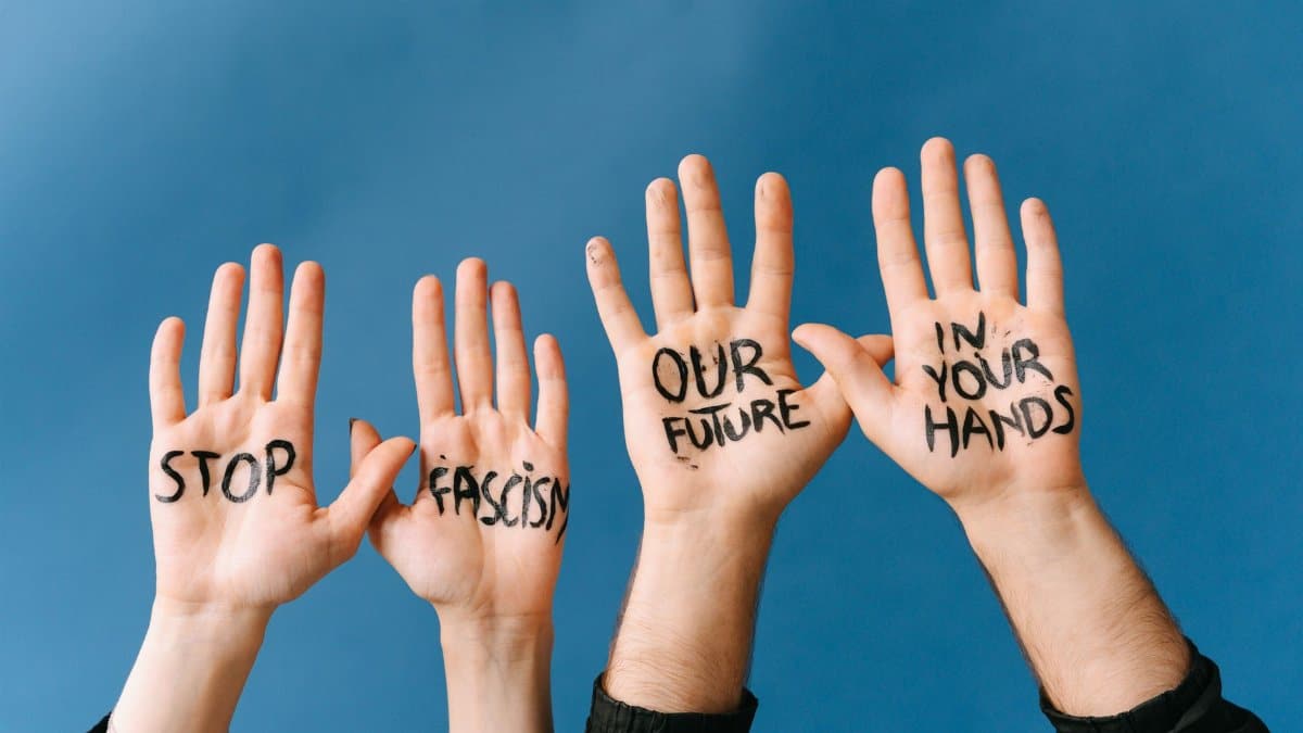 Four hands with messages against fascism for an activism campaign.