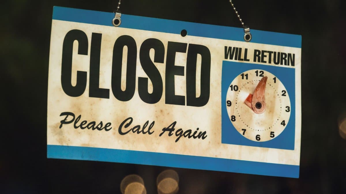 A vintage closed sign with adjustable clock in Estes Park, Colorado at night.