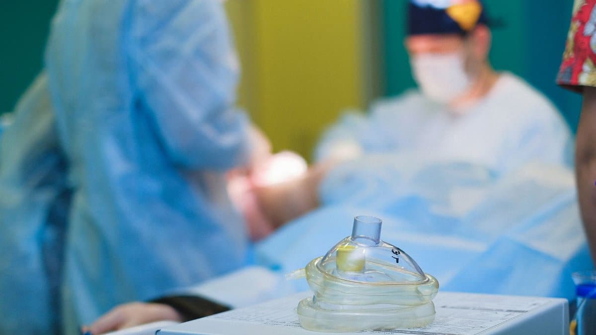 Medical team performing surgery in a sterile hospital operating room.