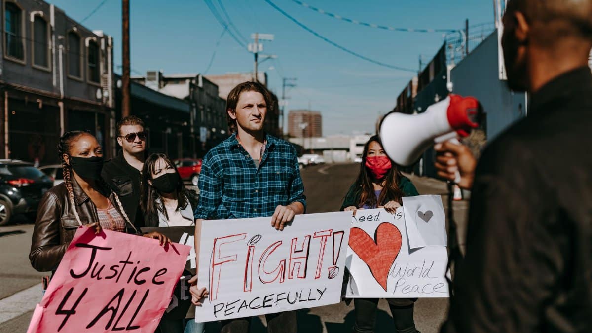 A diverse group of people peacefully demanding justice and equality in an outdoor protest.