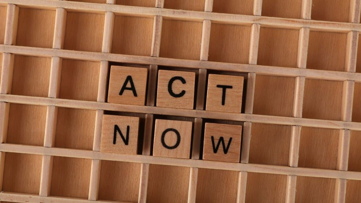 Wooden Scrabble letters spelling 'Act Now' on a grid, inspiring immediate action.