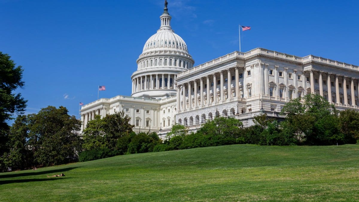 Stunning photo of the United States Capitol under a clear blue sky, showcasing neoclassical architecture.