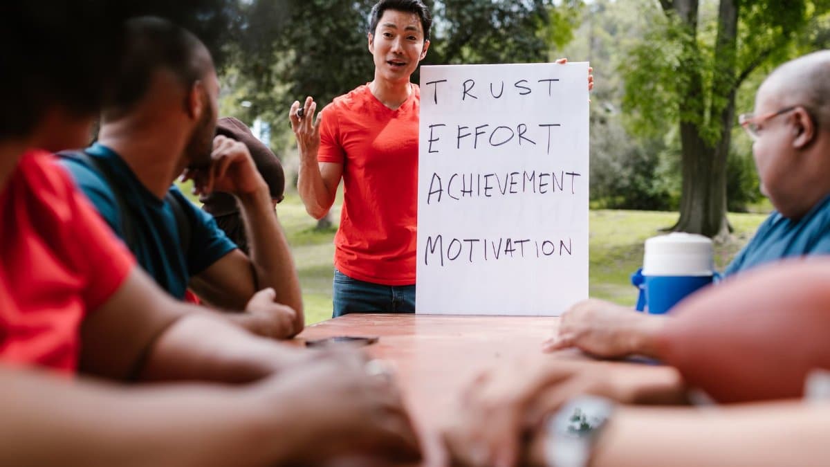 Diverse group engaged in outdoor team building, highlighting trust and effort.