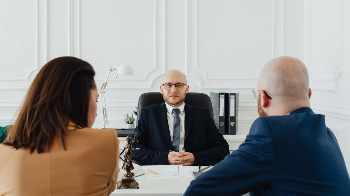 Lawyer meeting with clients in a formal office setting for legal consultation.