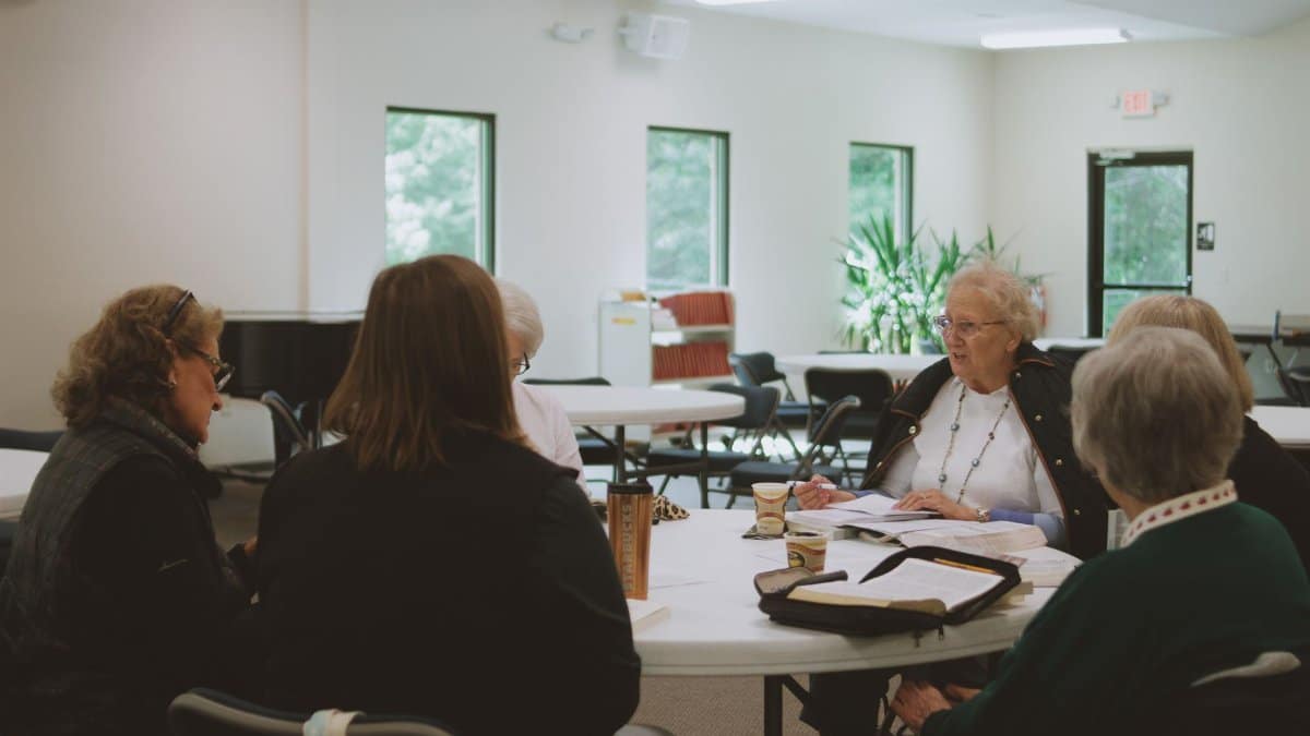 Older women engage in a thoughtful Bible study session at a local church in Brevard, NC.