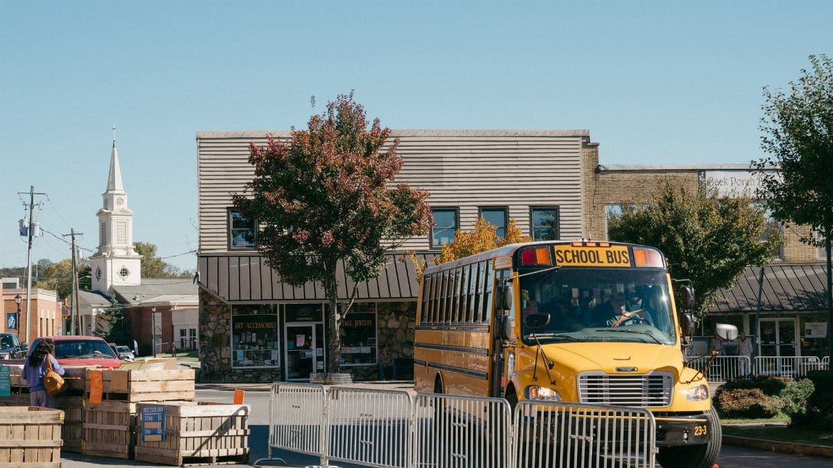Charming small town street with a school bus and autumn trees.