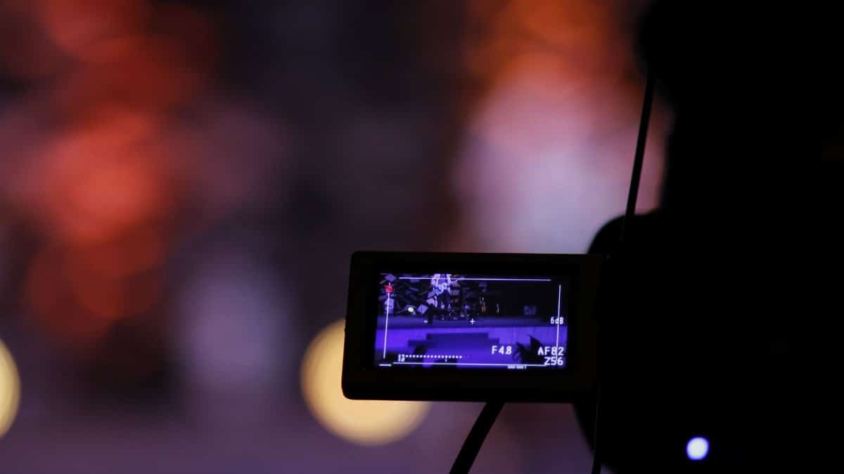 Close-up of a digital camera screen recording a scene with a vibrant bokeh background.