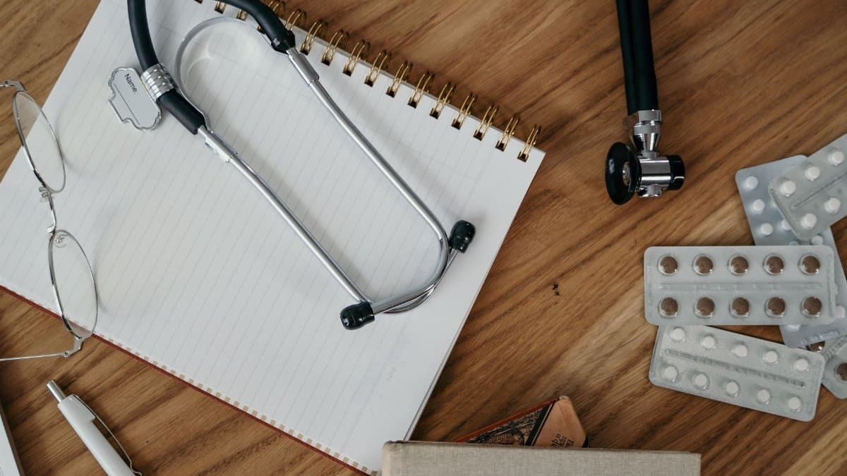 Flat lay of medical tools and supplies on a wooden desk surface.
