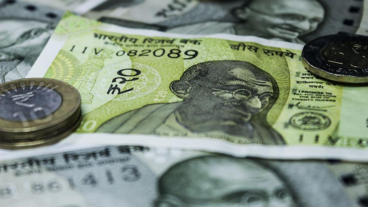 Close-up shot of Indian currency notes and coins, highlighting economic themes.