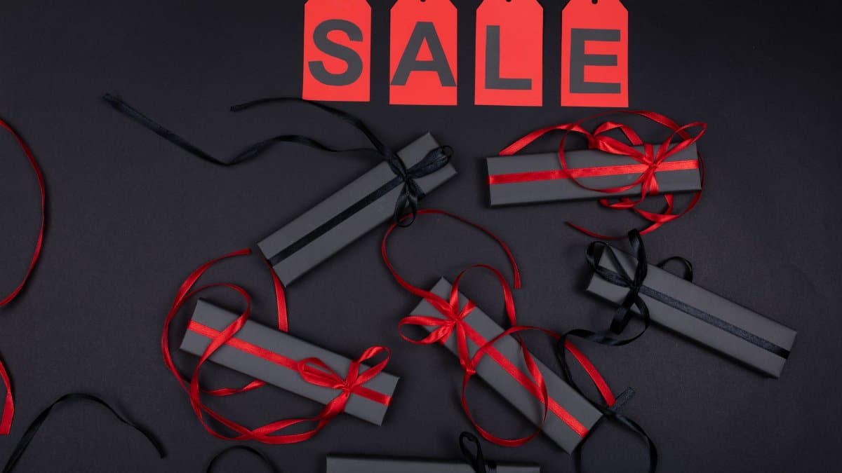 Elegant black gift boxes with red ribbons on sale promotion background.