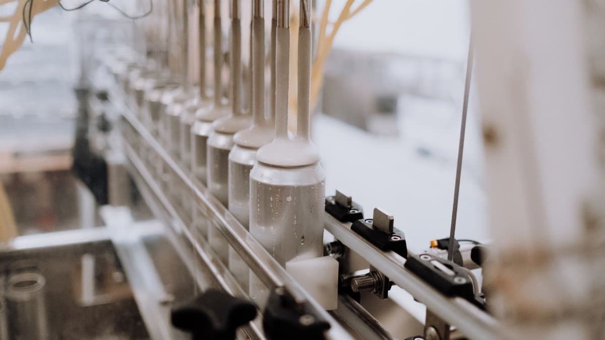 Close-up of automated canning equipment in a brewery, highlighting the manufacturing process.