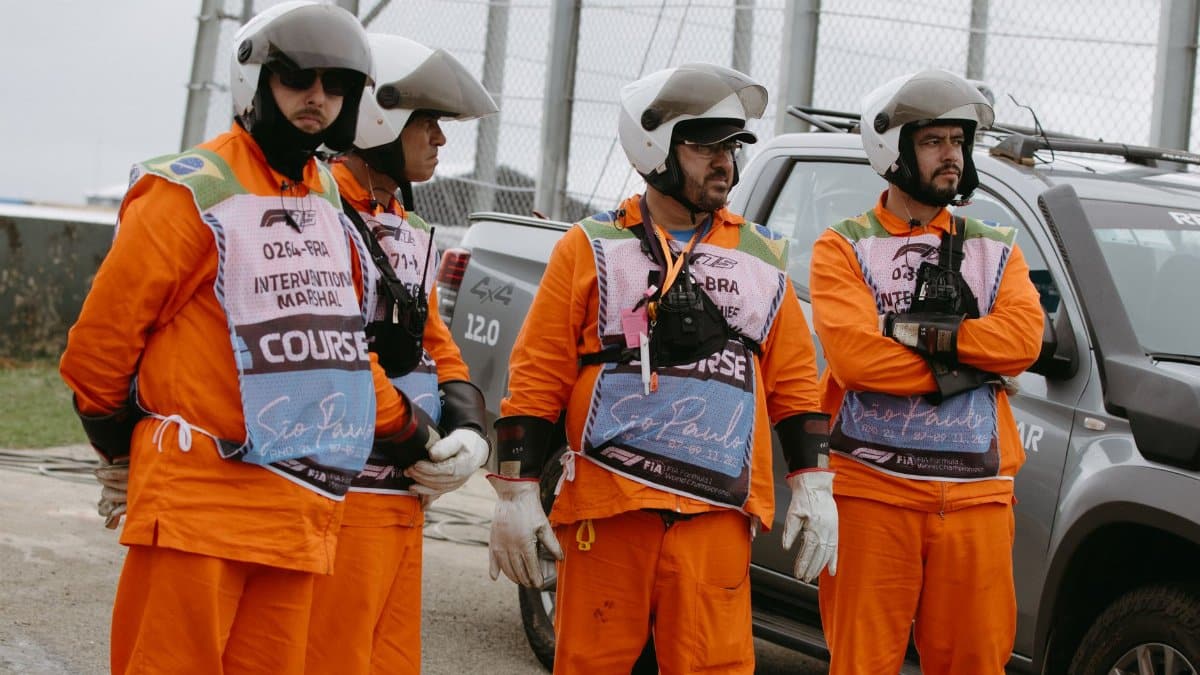Group of race marshals in protective gear at São Paulo Grand Prix circuit.