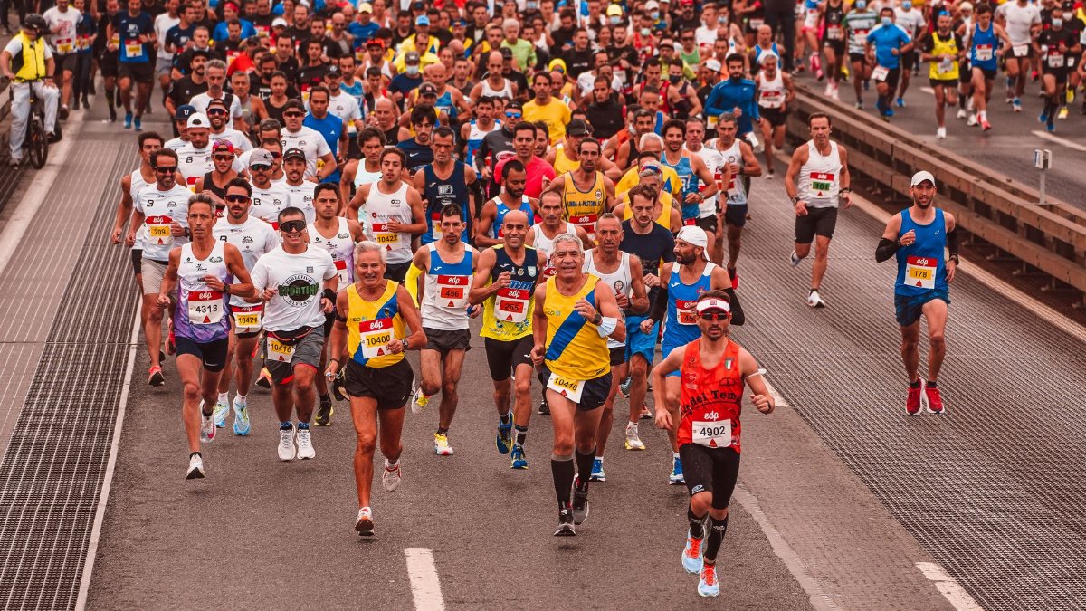 Large group of diverse athletes running a marathon outdoors during the day.