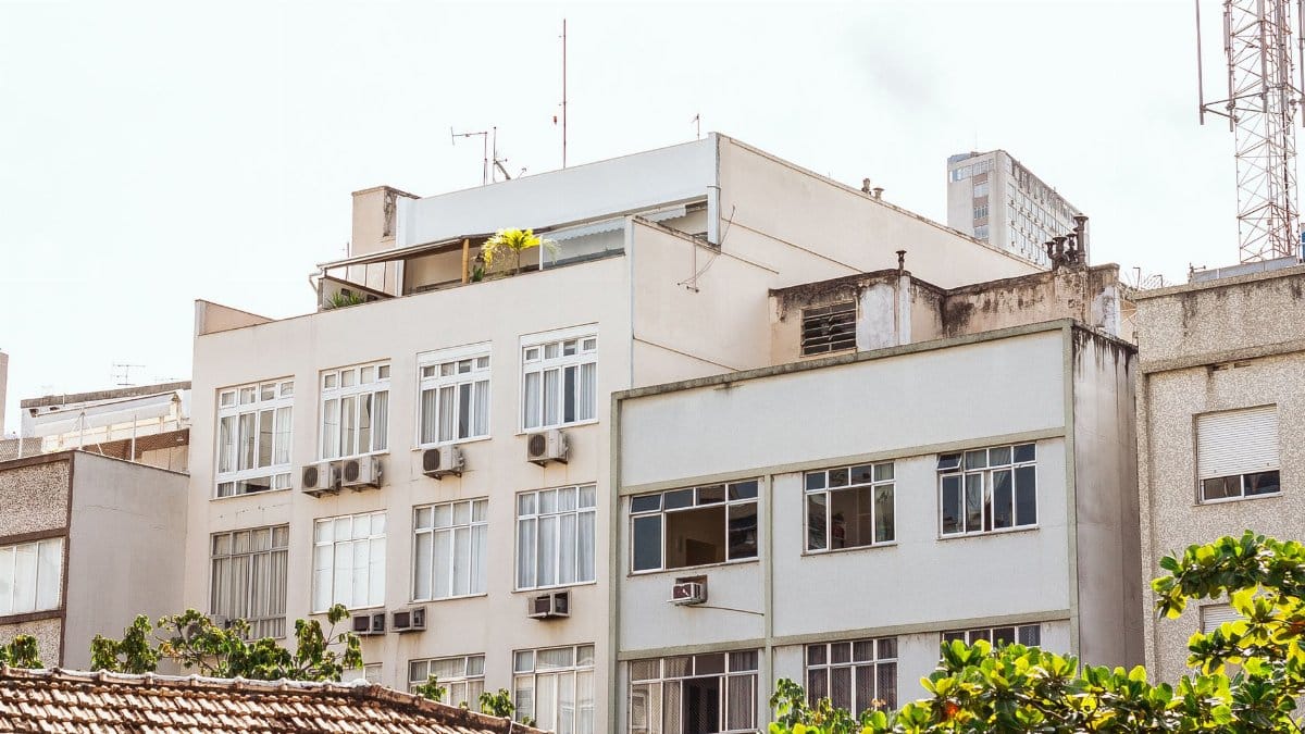 Contemporary residential building facade with air conditioning units in an urban setting.