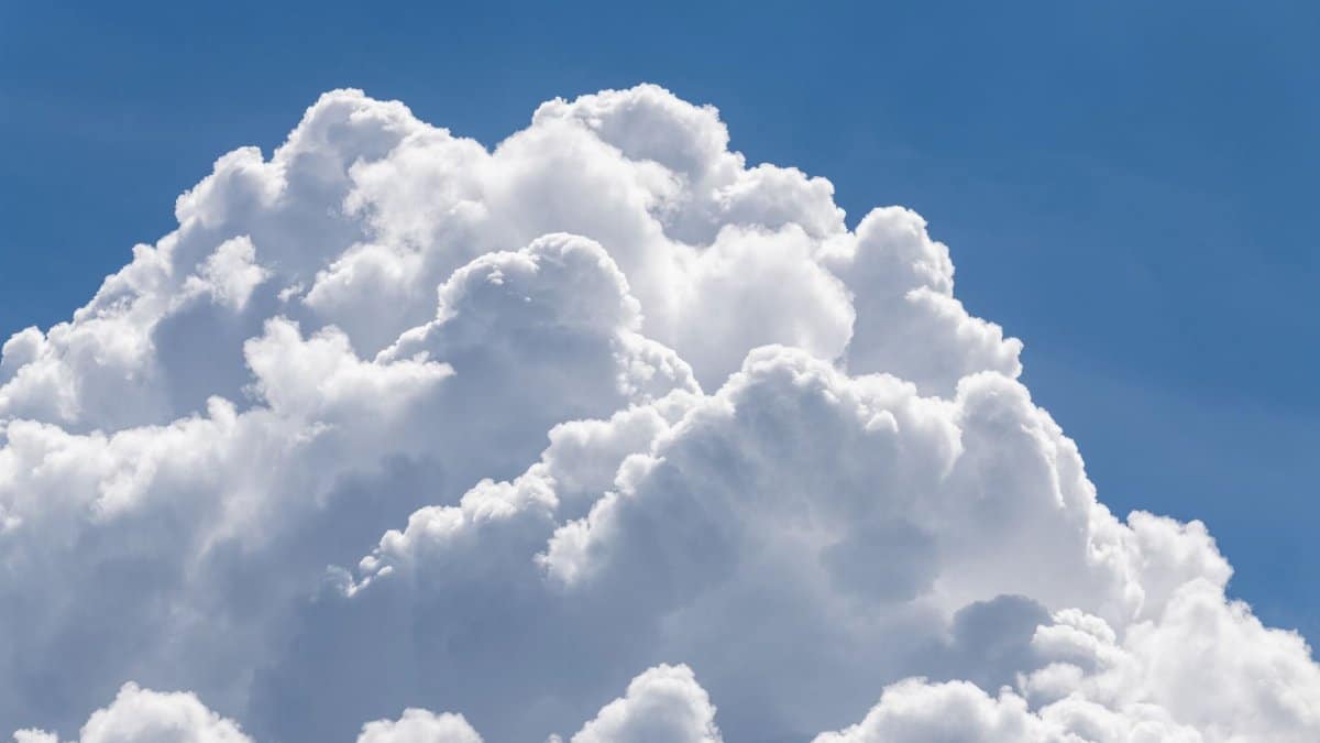 A bright, clear sky filled with fluffy cumulus clouds, perfect for summer or weather concepts.