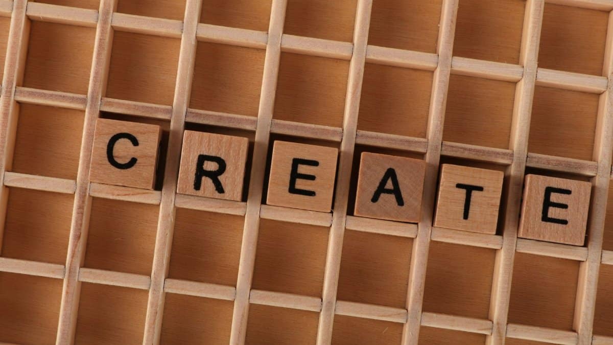 Wooden blocks in a grid forming the word CREATE, conveying creativity and innovation.