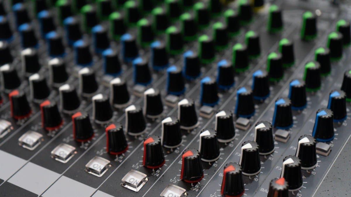 Detailed close-up of a professional sound mixer with colorful dials in rows, perfect for audio technology themes.