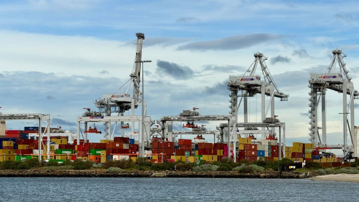 Colorful shipping containers and cranes at a bustling port in Victoria, Australia.