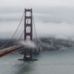 Aerial view of the Golden Gate Bridge enveloped in fog over San Francisco Bay.
