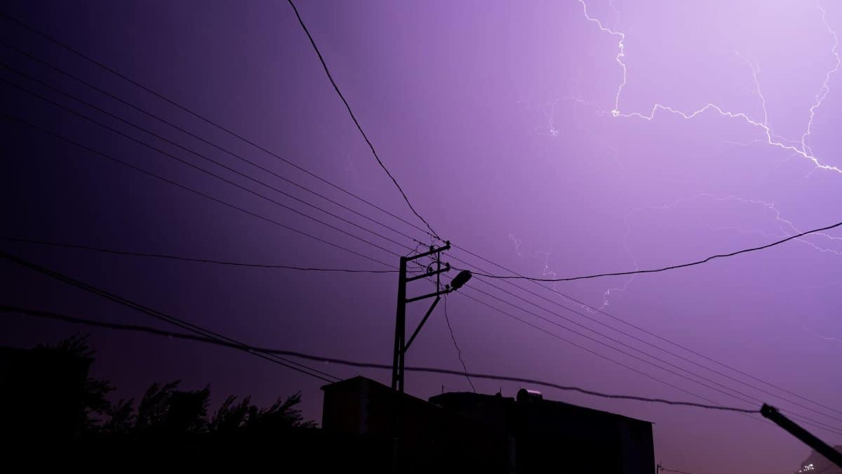 Captured in stunning clarity, a lightning storm illuminates the night sky above silhouetted urban structures.
